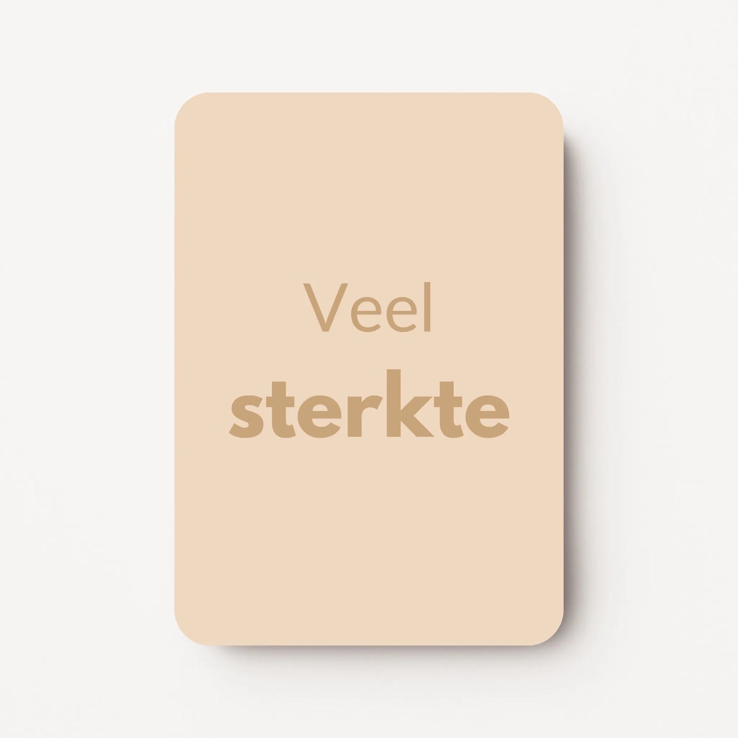 Staand minikaartje met goudbeige tekst ‘Veel sterkte’, minimalistisch ontwerp op een warme zandbeige achtergrond, flatlay op witte ondergrond.
