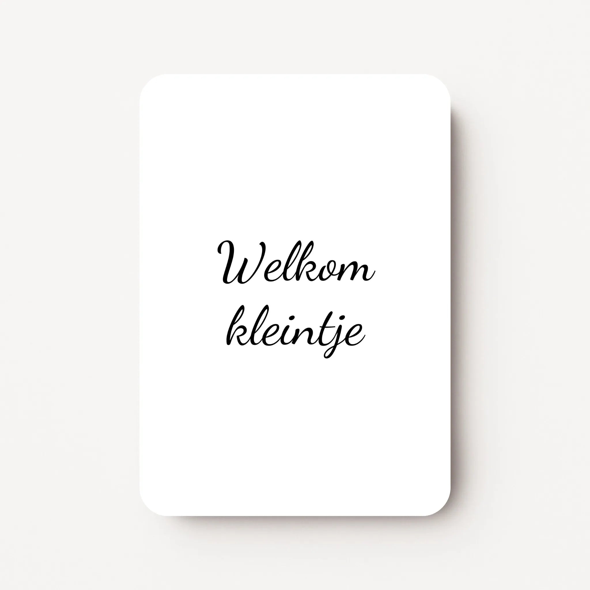 Staand minikaartje met zwarte tekst ‘Welkom kleintje’, minimalistisch ontwerp op witte achtergrond, flatlay op witte ondergrond.