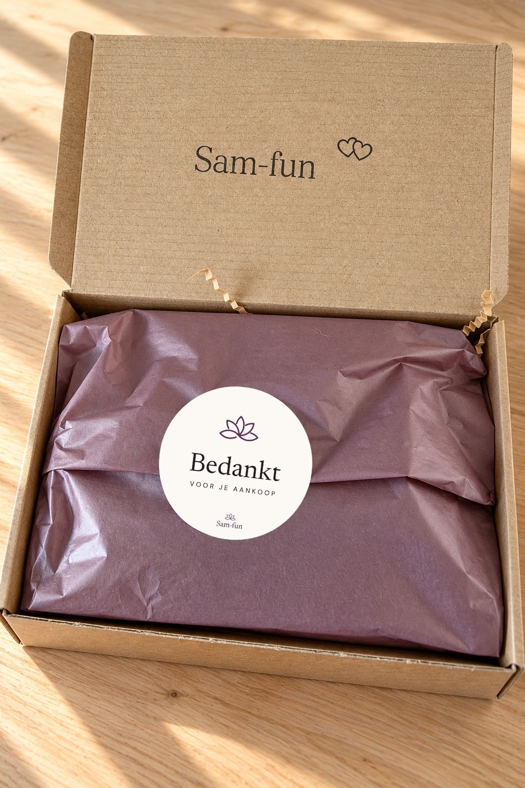 Open Sam-fun verzenddoos met mauvekleurig vloeipapier en bedanksticker tijdens het inpakken van een bestelling