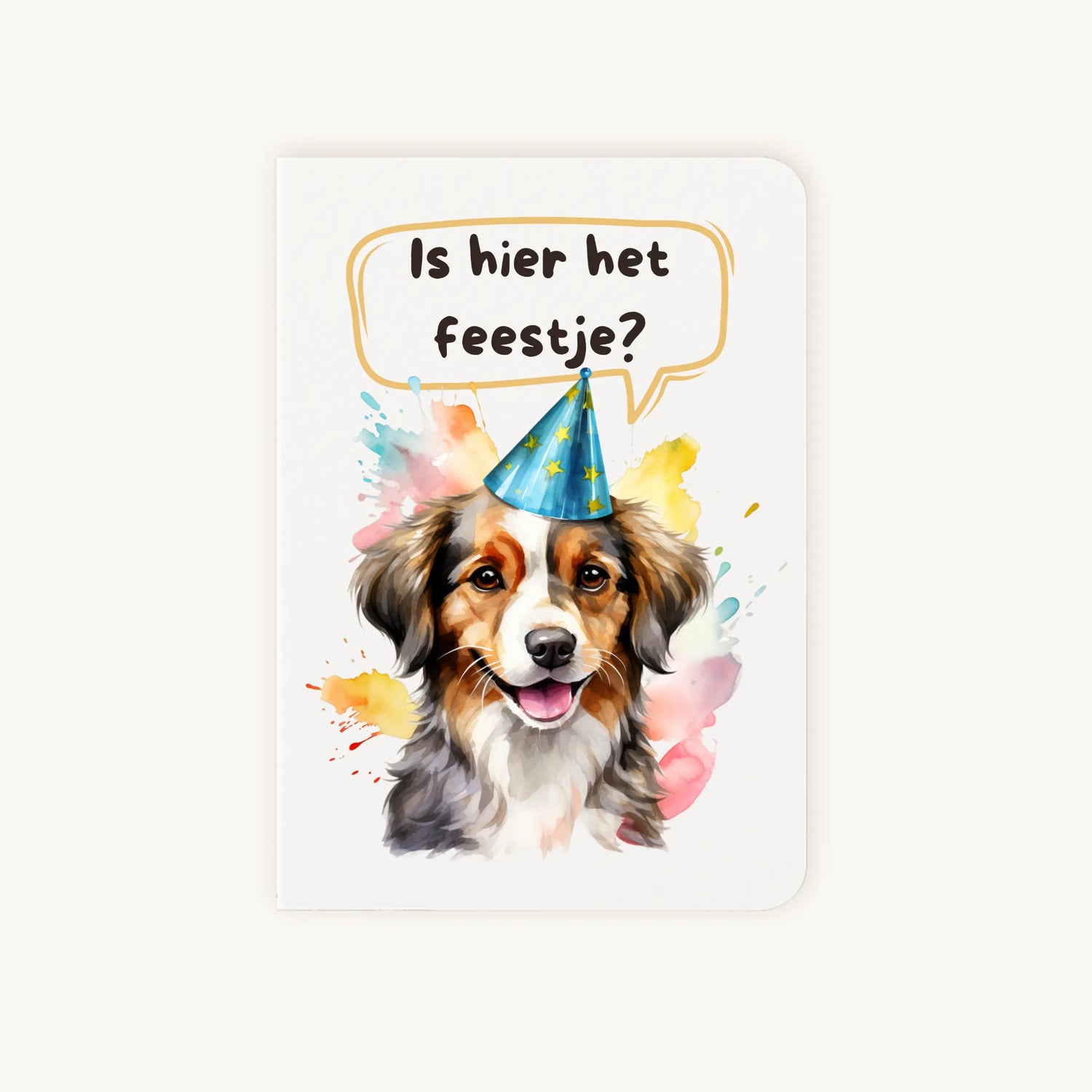 Staande dubbelgevouwen verjaardagskaart met vrolijke hond met feesthoedje en tekst Is hier het feestje?, flatlay op lichte achtergrond.