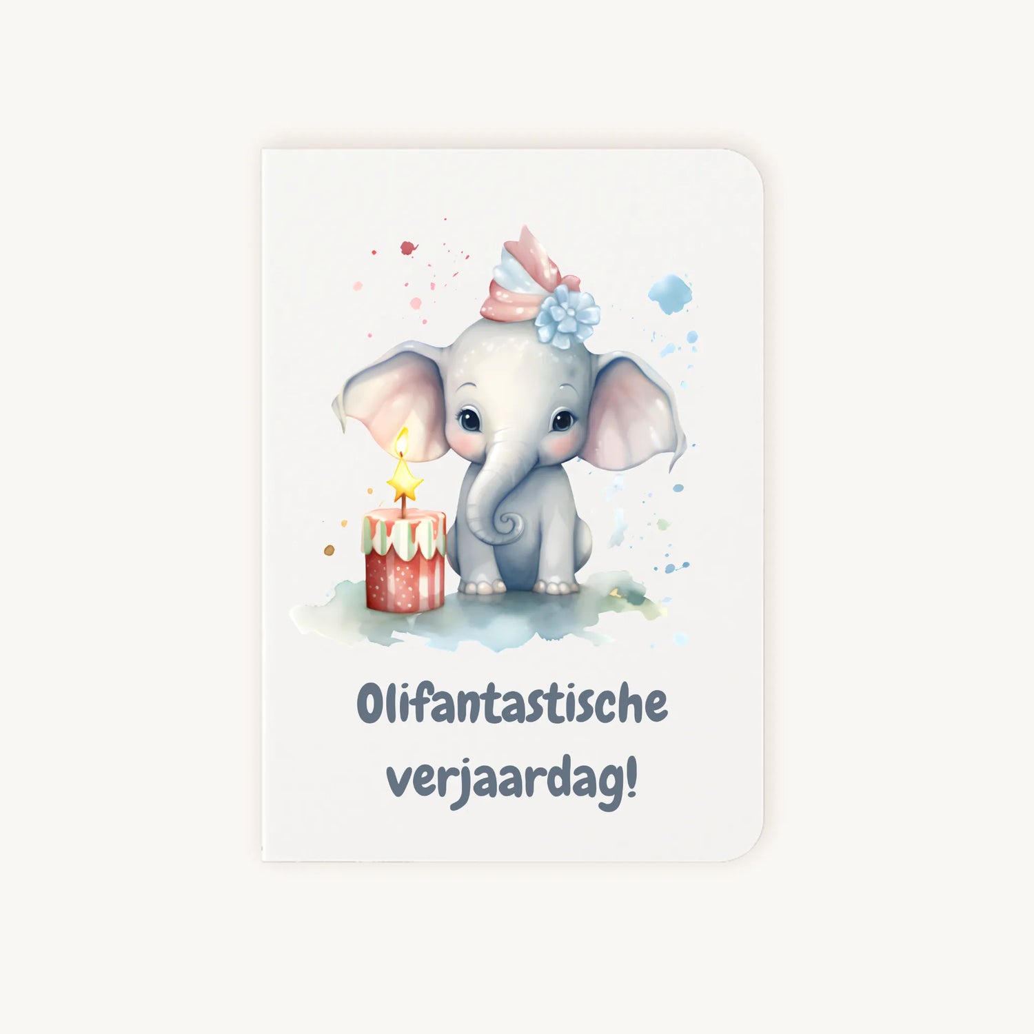 Staande dubbelgevouwen verjaardagskaart met vrolijke olifant met feestmuts en taartje, met tekst Olifantastische verjaardag, flatlay op lichte achtergrond.