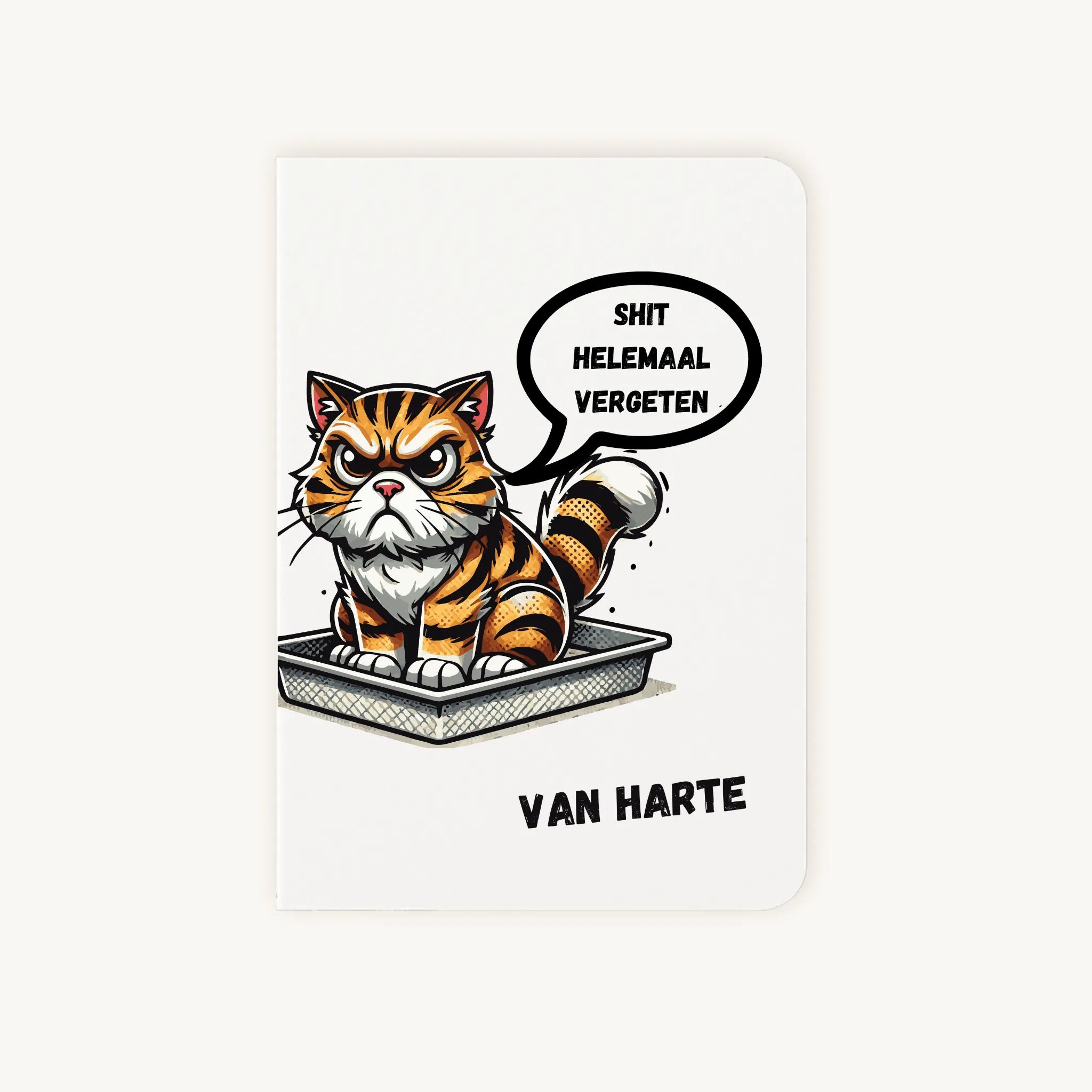 Staande dubbelgevouwen verjaardagskaart met chagrijnige getekende tijgerkat in een kattenbak, kleurrijke humoristische illustratie en tekst Shit helemaal vergeten van harte, flatlay op lichte achtergrond.