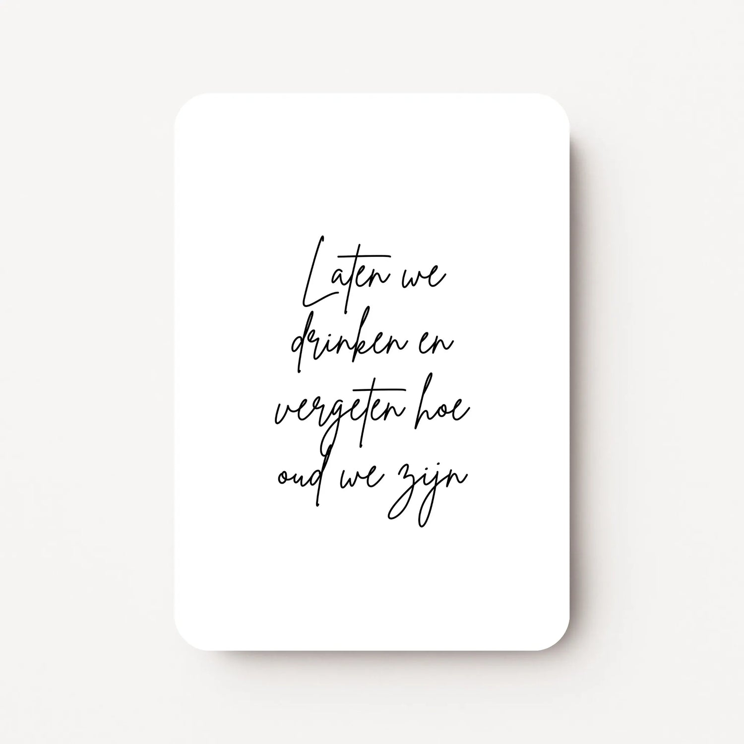 Staande verjaardagskaart voor een vrouw met zwarte tekst ‘Laten we drinken en vergeten hoe oud we zijn’, minimalistisch ontwerp op witte achtergrond, flatlay op witte ondergrond.