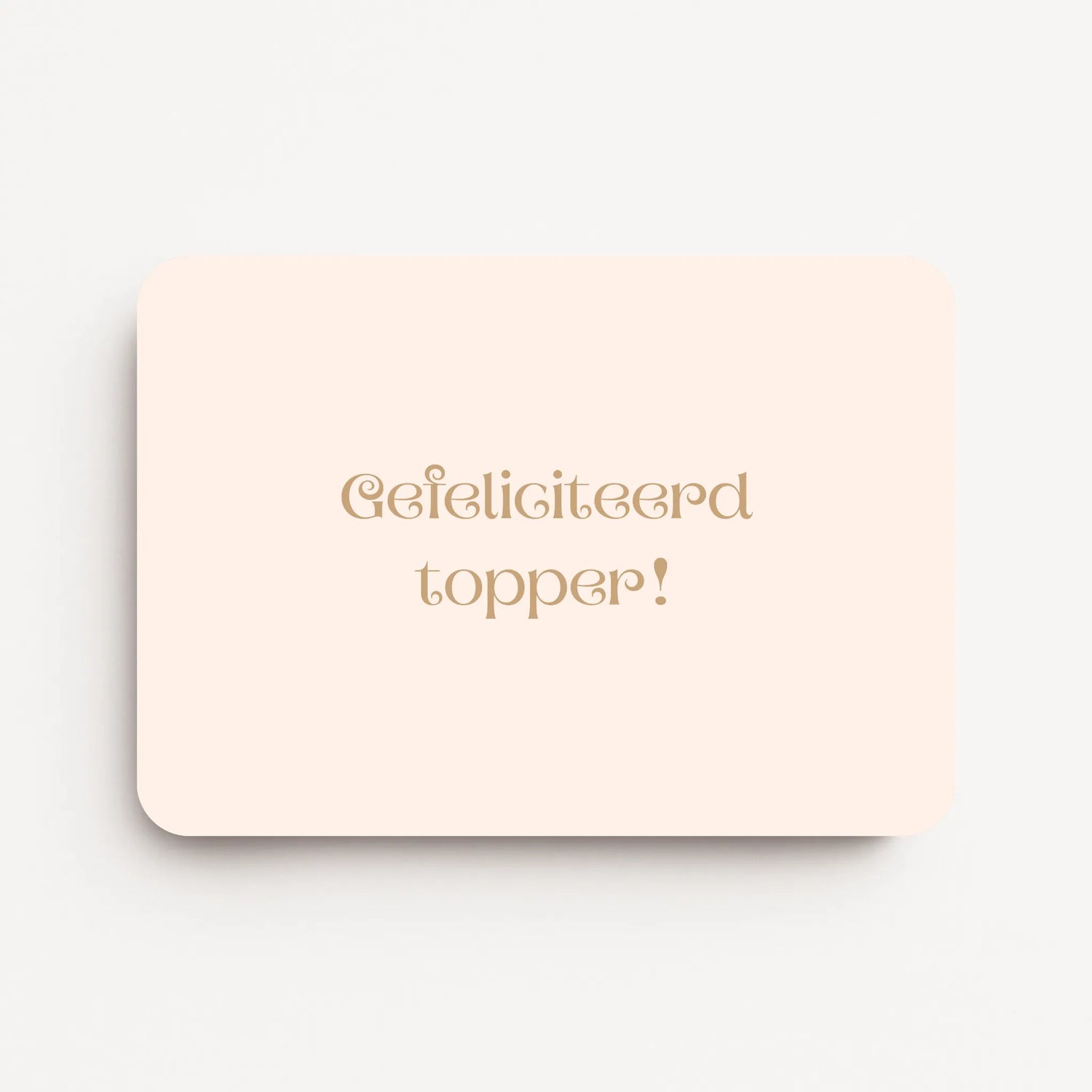Liggende verjaardagskaart voor een vrouw met warm beige tekst ‘Gefeliciteerd topper!’ op een zachte crème achtergrond, flatlay op witte ondergrond.