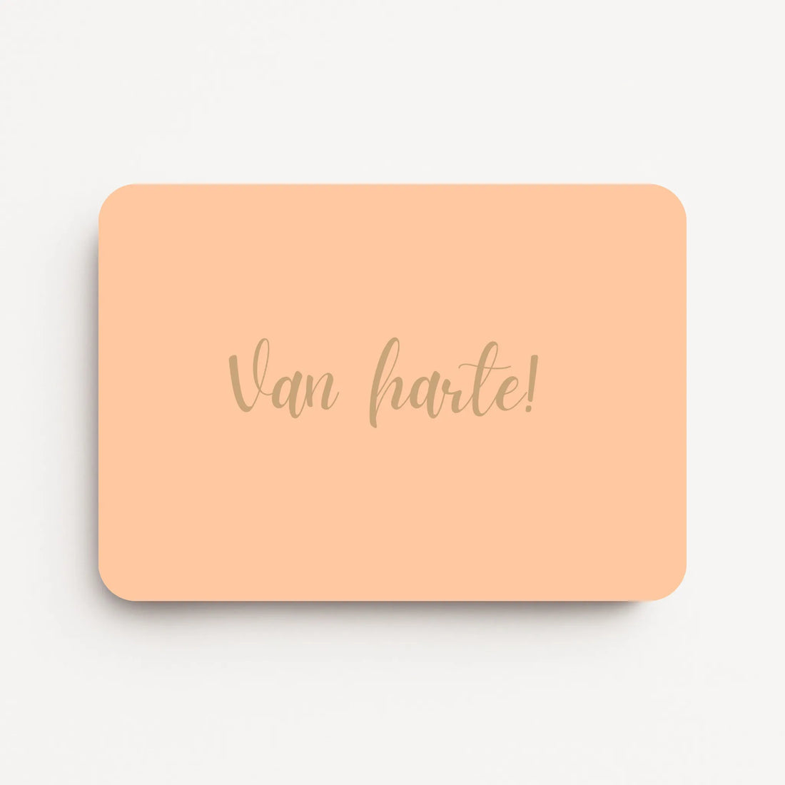 Liggende verjaardagskaart voor een vrouw met warm beige tekst ‘Van harte!’ op een warme perzikkleurige achtergrond, flatlay op witte ondergrond.