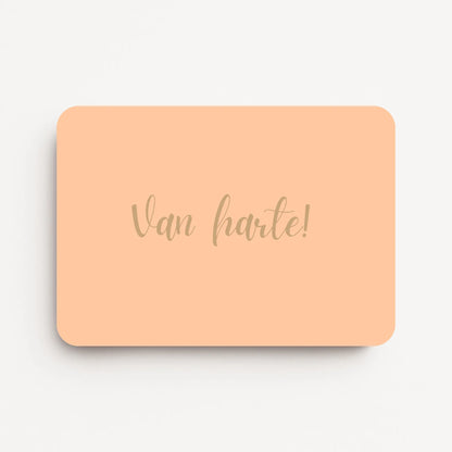 Liggende verjaardagskaart voor een vrouw met warm beige tekst ‘Van harte!’ op een warme perzikkleurige achtergrond, flatlay op witte ondergrond.