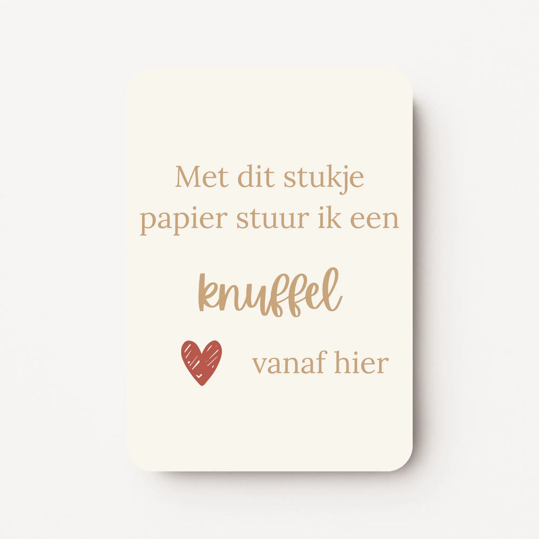 Staande kaart met tekst ‘Met dit stukje papier stuur ik een knuffel vanaf hier’ in goudbruine letters met een klein rood hartje, op een crème achtergrond, flatlay op witte ondergrond.