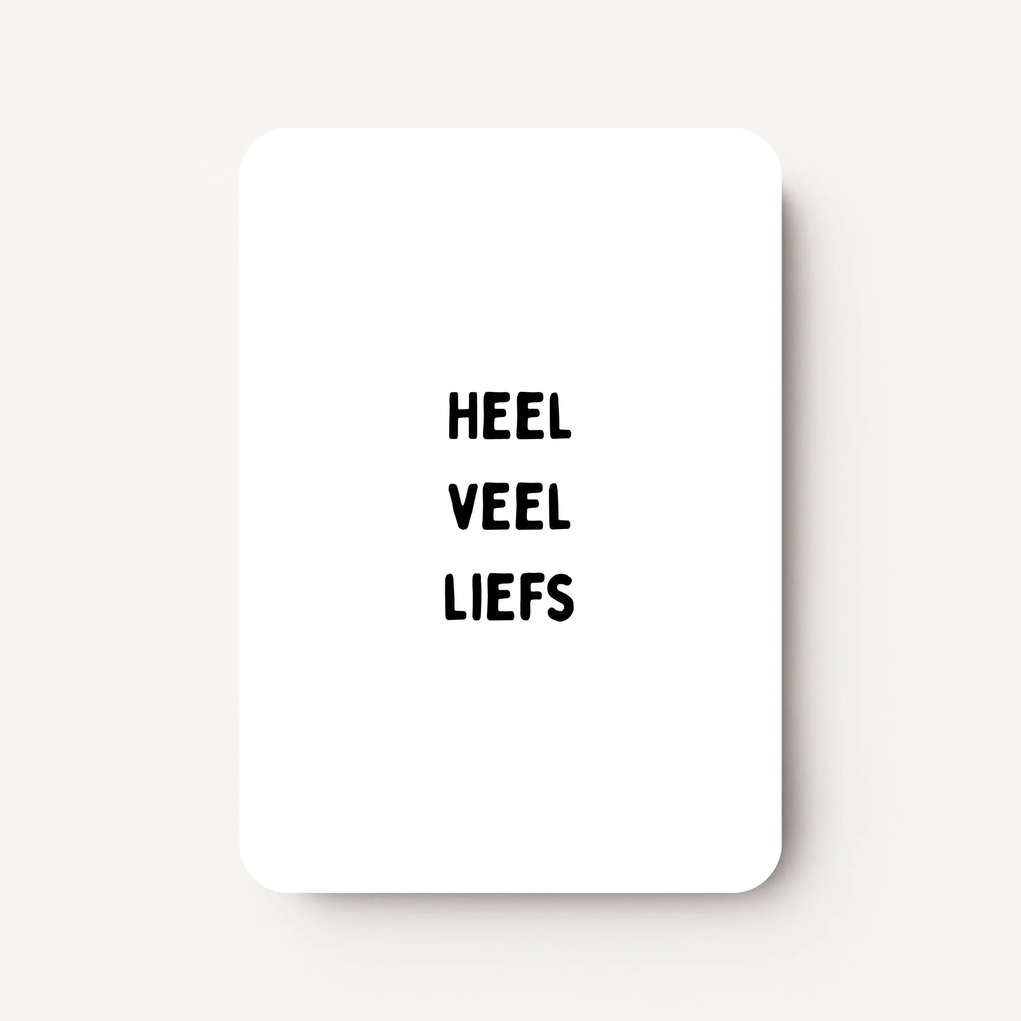 Staande zomaarkaart met zwarte tekst ‘Heel veel liefs’, minimalistisch ontwerp op witte achtergrond, flatlay op witte ondergrond.