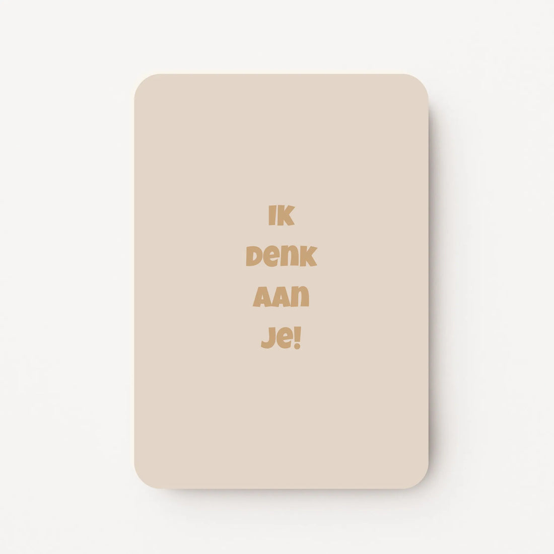 Staande kaart met tekst ‘Ik denk aan je!’ in goudbruine letters op een warme beige achtergrond, flatlay op witte ondergrond.