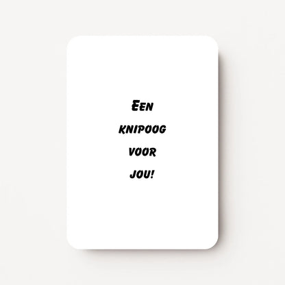Staande zomaarkaart met zwarte tekst ‘Een knipoog voor jou!’, minimalistisch ontwerp op witte achtergrond, flatlay op witte ondergrond.