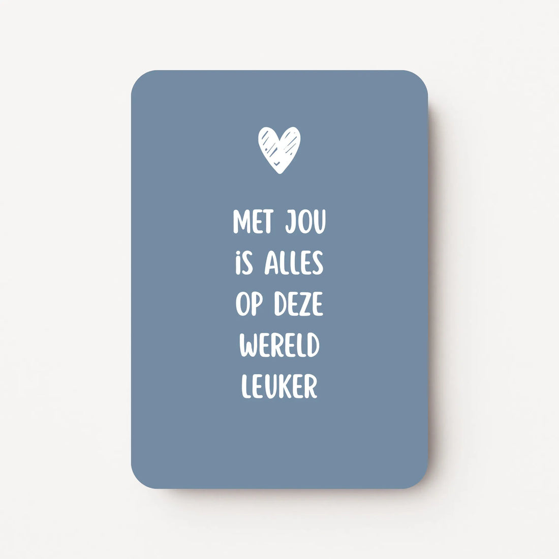 Staande kaart met tekst ‘Met jou is alles op deze wereld leuker’ in witte letters met een wit hartje, op een koele blauwgrijze achtergrond, flatlay op witte ondergrond.