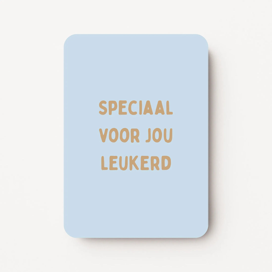 Staande kaart met tekst ‘Speciaal voor jou leukerd’ in goudbruine letters op een zachtblauwe achtergrond, flatlay op witte ondergrond.
