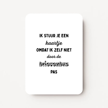Staande zomaarkaart met zwarte tekst ‘Ik stuur je een kaartje omdat ik zelf niet door de brievenbus pas’, flatlay op witte ondergrond.