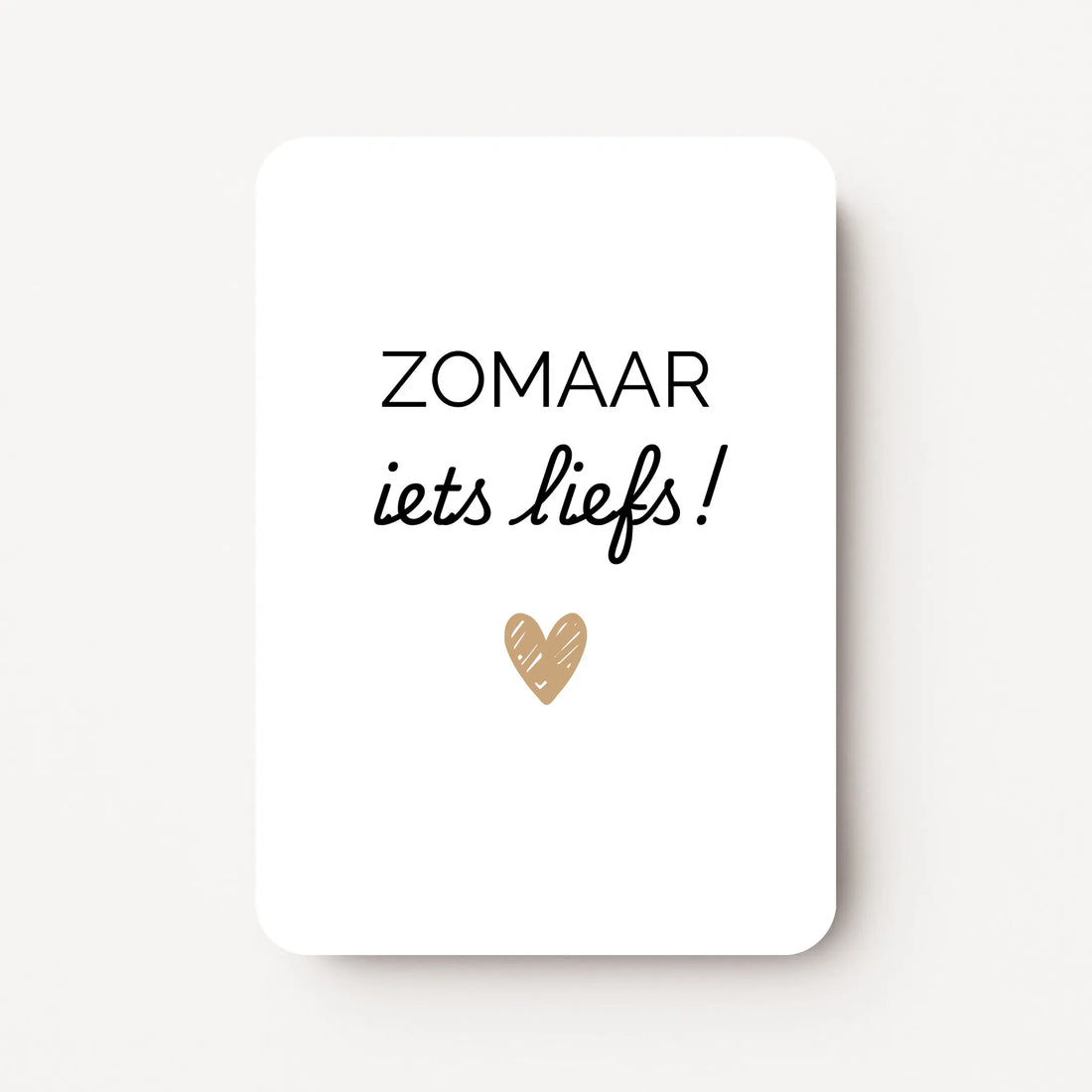 Staande kaart met zwarte tekst ‘ZOMAAR iets liefs!’ en een klein goudbruin hartje eronder, op witte achtergrond, flatlay op witte ondergrond.